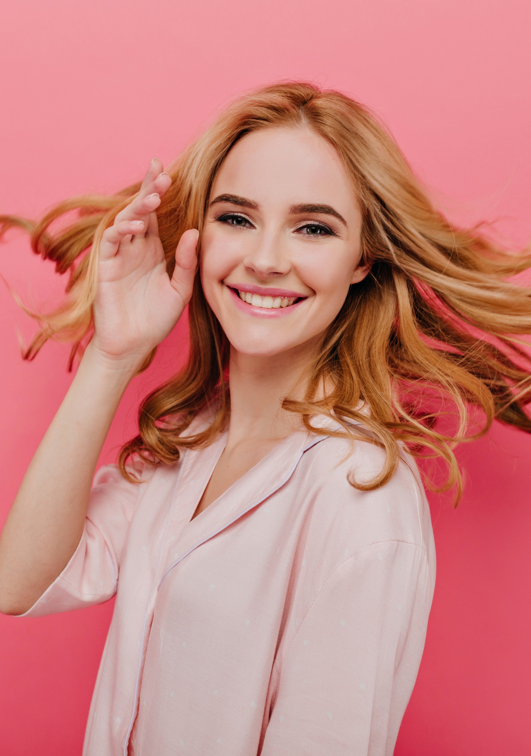 Close-up portrait of happy young woman with beautiful blonde hair isolated on pink background. Photo of glad caucasian lady wears cotton night-suit.